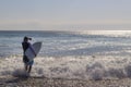 Male surfer entering the sea with his board.Ready for a great surfing day