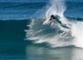 A male surfer executing a slashing backside top-turn off-the-lip at Iluka`s North Wall. Royalty Free Stock Photo