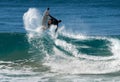 A male surfer exiting a wave with acrobatic style.