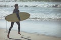 Male surfer with a surfboard running on a beach Royalty Free Stock Photo