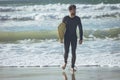 Male surfer with a surfboard walking on a beach Royalty Free Stock Photo