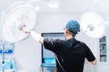 surgeon getting ready for surgery, fixing lamps and adjusting light in operation room Royalty Free Stock Photo