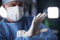 Male surgeon putting on latex gloves in preparation