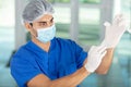 male surgeon putting on latex gloves in preparation Royalty Free Stock Photo