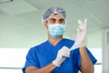 male surgeon putting on latex gloves in preparation Royalty Free Stock Photo