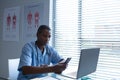 Male surgeon using mobile phone at desk Royalty Free Stock Photo