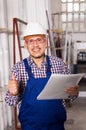 Male surveyor in coverall doing checkup and filling papers