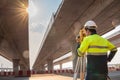 A male surveyor engineers worker use radio communication and making measuring with theodolite on road works. Survey engineer at Royalty Free Stock Photo