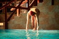 A male swimmer dives into the pool with his head into the water, the start of the swim in the pool. Royalty Free Stock Photo