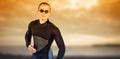 Male swimmer standing against cloudy sky during sunset