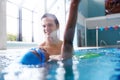 Male Swimming Coach Giving Boy Learning Backstroke One To One Lesson In Pool