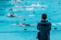 Male swimming coach standing by the swimming pool in the rain wa