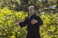 A male tai Chi master practices qigong in nature in a Park Royalty Free Stock Photo