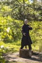 A male tai Chi master practices qigong in nature standing on a stump Royalty Free Stock Photo