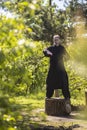 A male tai Chi master practices qigong in nature standing on a stump Royalty Free Stock Photo