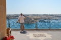 Male taking a picture of a beautiful view of Malta from a balcony