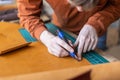 Male tanner making cutting scheme of bag working at leather workshop. Handcrafted creating