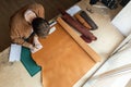 Male tanner making cutting scheme of bag working at leather workshop. Handcrafted creating