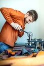 Male tanner working with handpress device machine cutting pattern on stuff material leather workshop Royalty Free Stock Photo