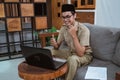 male teacher in civil servant uniform with hand gestures during online meeting using a laptop computer