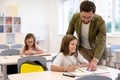 Male teacher helping pupils while writing the test Royalty Free Stock Photo