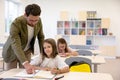 Male teacher helping pupils while writing the test Royalty Free Stock Photo