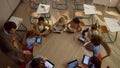 Male teacher helping students with tablet computers at lesson.