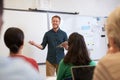 Male teacher listening to students at adult education class Royalty Free Stock Photo