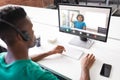 Male teacher teaching african american boy through desktop pc during online class in school