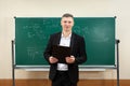 The male teacher used white chalk to write on the blackboard to teach students in a class Royalty Free Stock Photo