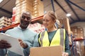 Male Team Leader With Clipboard In Warehouse Training Intern Standing By Shelves Royalty Free Stock Photo