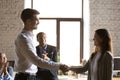 Male team leader handshaking female excited employee congratulat Royalty Free Stock Photo