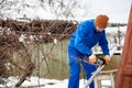 Male technician in blue suit cutting metal with cutting wheel getting ready to install photovoltaic solar panels Royalty Free Stock Photo