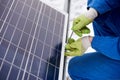 Male technician in blue suit installing photovoltaic blue solar modules with Royalty Free Stock Photo