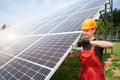 Male technician checks the maintenance of the solar panels. Orange safety cap on his head