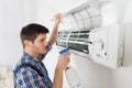 Male Technician Cleaning Air Conditioner