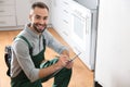 Male technician with clipboard examining refrigerator Royalty Free Stock Photo