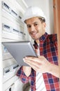 male technician examining fusebox while holding tablet Royalty Free Stock Photo