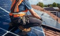 Male technician installing photovoltaic blue solar panel on a rooftop