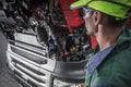 Auto Mechanic Looking Under Hood Of Car