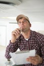 male technician looking at smoke detector and taking notes Royalty Free Stock Photo