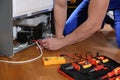 Male technician repairing broken refrigerator, closeup Royalty Free Stock Photo