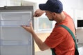 Male technician with screwdriver repairing refrigerator Royalty Free Stock Photo