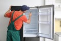 Male technician with screwdriver repairing refrigerator Royalty Free Stock Photo