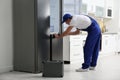 Male technician with screwdriver repairing refrigerator Royalty Free Stock Photo