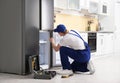 Male technician with screwdriver repairing refrigerator Royalty Free Stock Photo