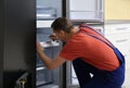 Male technician with screwdriver repairing refrigerator Royalty Free Stock Photo