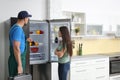 Male technician talking with client near refrigerator Royalty Free Stock Photo