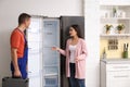 Male technician talking with client near refrigerator Royalty Free Stock Photo