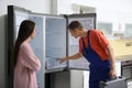 Male technician talking with client near refrigerator Royalty Free Stock Photo